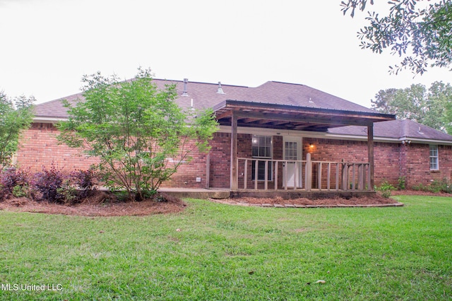 rear view of property with brick siding and a lawn