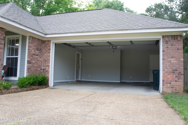garage with driveway and a garage door opener