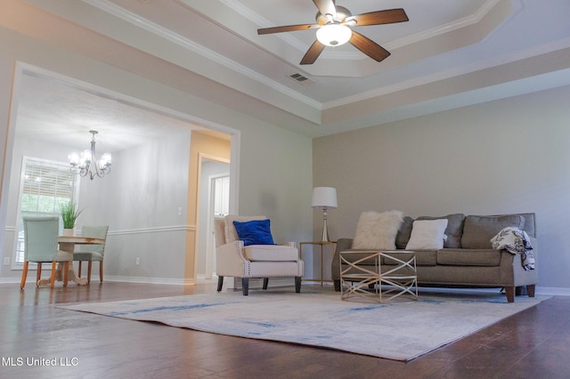 living area featuring wood finished floors, a chandelier, crown molding, baseboards, and a ceiling fan