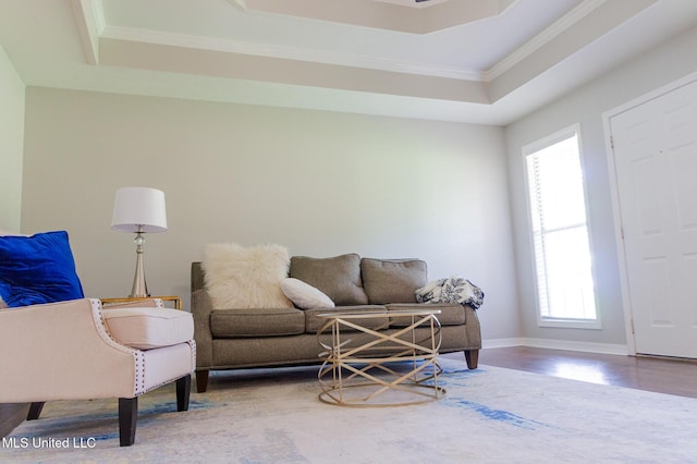 living area with plenty of natural light, a tray ceiling, wood finished floors, and crown molding