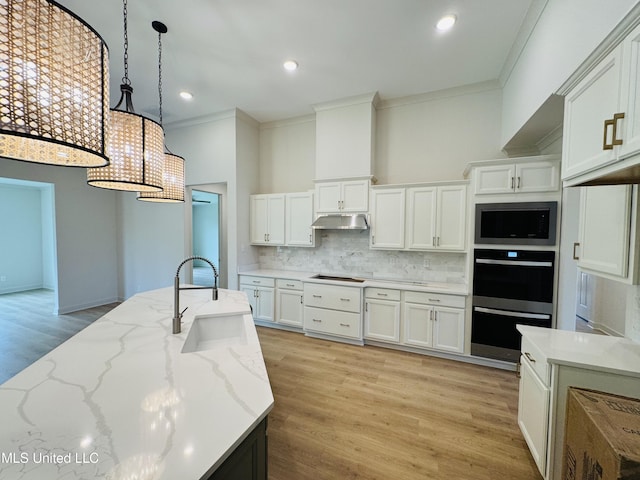 9549 Mcelroy Farms Dr, Olive Branch, MS 38654 - kitchen featuring under cabinet range hood, ornamental molding, a sink, stainless steel microwave, and backsplash
