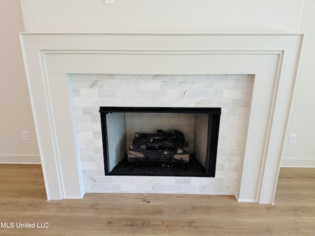 9549 Mcelroy Farms Dr, Olive Branch, MS 38654 - detailed view of wood finished floors, a tile fireplace, and baseboards