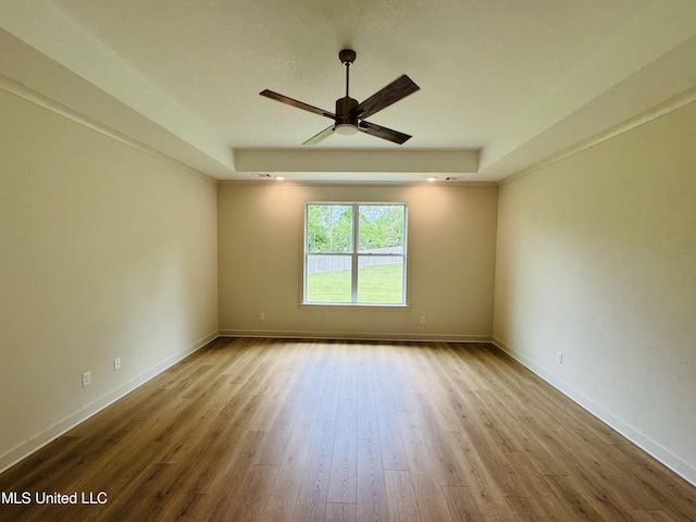 9549 Mcelroy Farms Dr, Olive Branch, MS 38654 - empty room featuring ceiling fan, a raised ceiling, wood finished floors, and baseboards