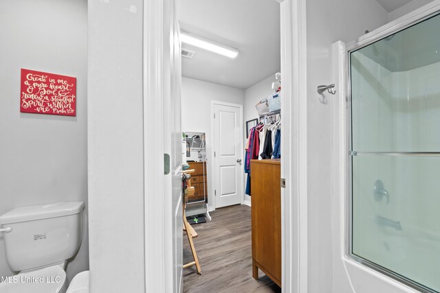 13400 Willow Oak Cir, Gulfport, MS 39503 - full bathroom with wood finished floors, toilet, bath / shower combo with glass door, and a spacious closet