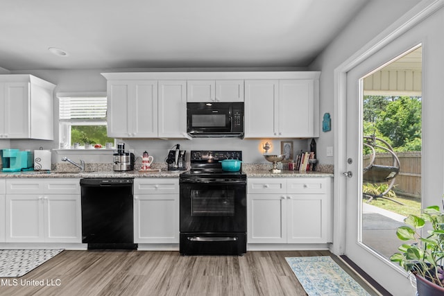 13400 Willow Oak Cir, Gulfport, MS 39503 - kitchen featuring black appliances, white cabinets, light wood-style floors, light stone counters, and a sink