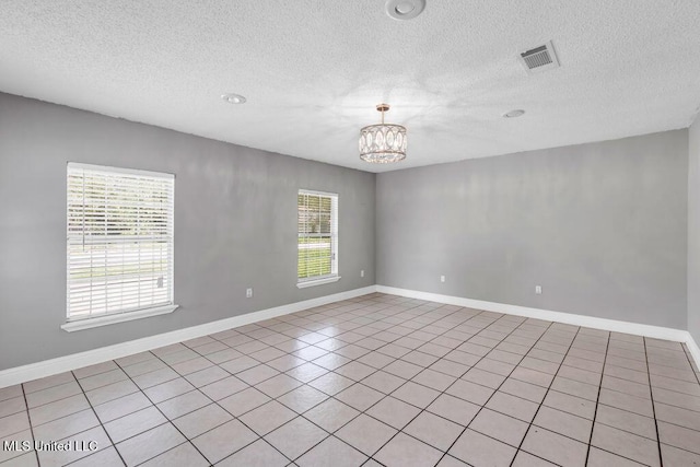 1320 Sally Dr, Picayune, MS 39466 - spare room featuring a chandelier, a textured ceiling, baseboards, and light tile patterned floors