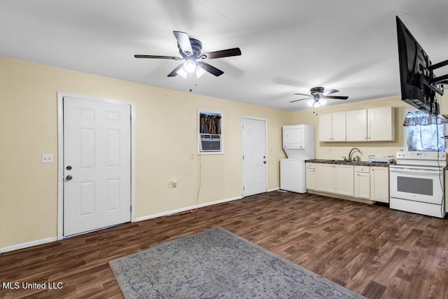 1320 Sally Dr, Picayune, MS 39466 - kitchen featuring white electric range oven, ceiling fan, stacked washer and clothes dryer, dark wood-type flooring, and baseboards