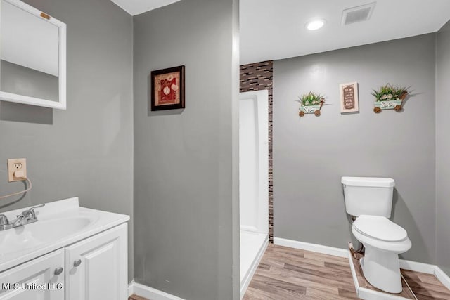 1320 Sally Dr, Picayune, MS 39466 - bathroom featuring baseboards, toilet, vanity, wood finished floors, and recessed lighting