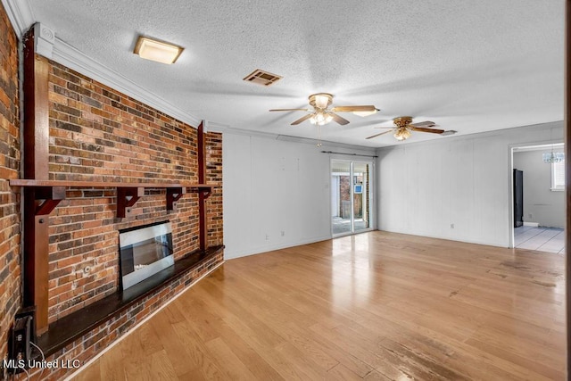 1320 Sally Dr, Picayune, MS 39466 - unfurnished living room with a ceiling fan, a brick fireplace, healthy amount of natural light, a textured ceiling, and crown molding