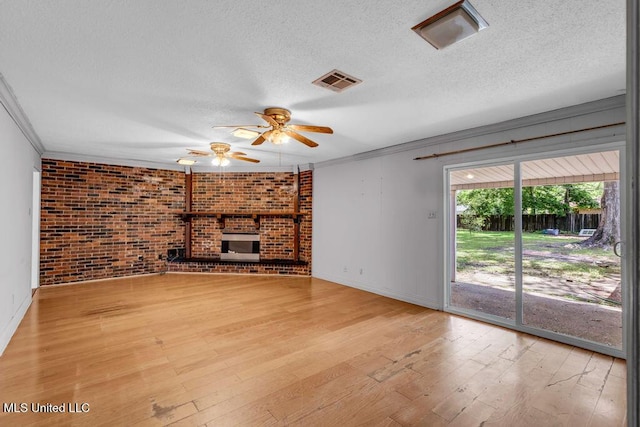 1320 Sally Dr, Picayune, MS 39466 - unfurnished living room featuring crown molding, ceiling fan, light wood finished floors, a textured ceiling, and brick wall