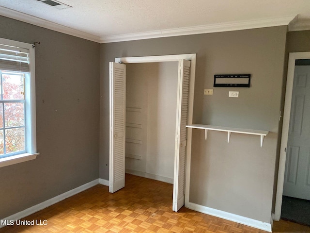 unfurnished bedroom featuring light parquet flooring, a textured ceiling, and ornamental molding