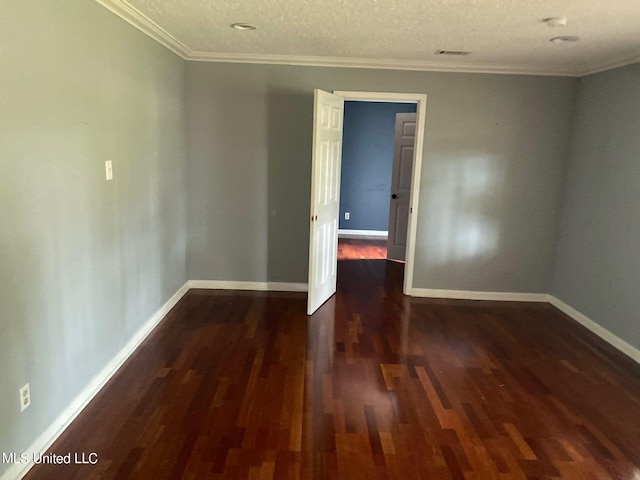 spare room with a textured ceiling, ornamental molding, and dark hardwood / wood-style flooring