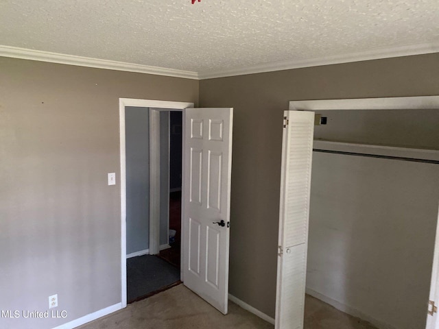 unfurnished bedroom with a closet, light carpet, a textured ceiling, and ornamental molding