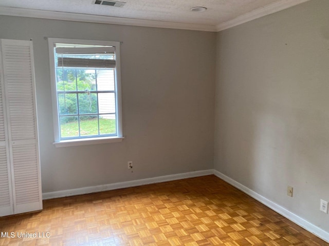 empty room with ornamental molding, a textured ceiling, and light parquet flooring