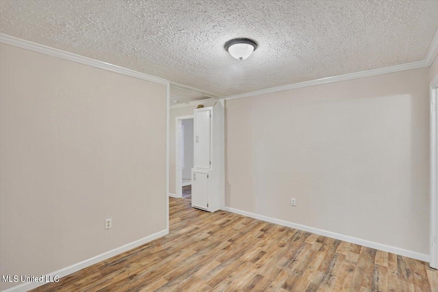 empty room featuring ornamental molding, light hardwood / wood-style flooring, and a textured ceiling