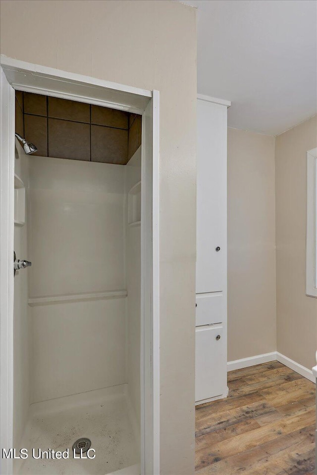 bathroom featuring wood-type flooring and walk in shower