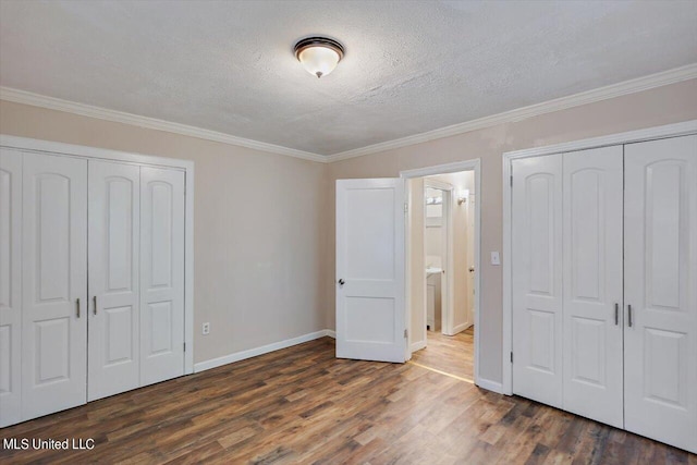 unfurnished bedroom with ornamental molding, a textured ceiling, and dark hardwood / wood-style flooring