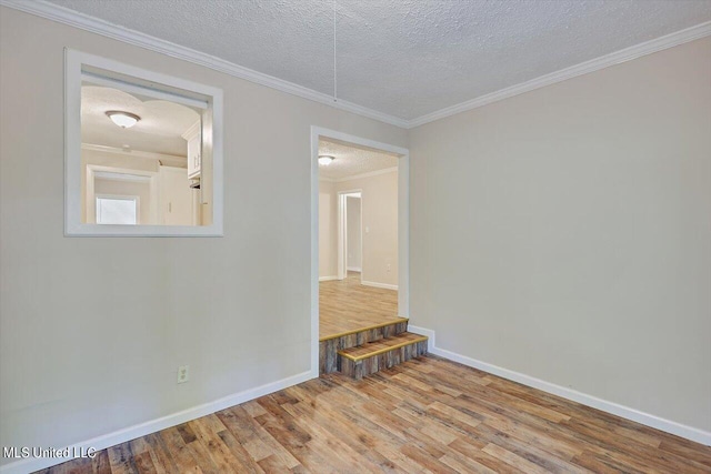 empty room with crown molding, hardwood / wood-style flooring, and a textured ceiling