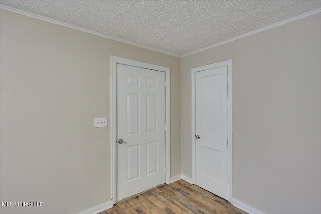 spare room with ornamental molding, hardwood / wood-style floors, and a textured ceiling