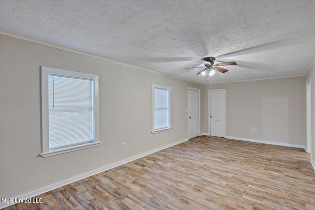 spare room featuring ornamental molding, a textured ceiling, light hardwood / wood-style floors, and ceiling fan