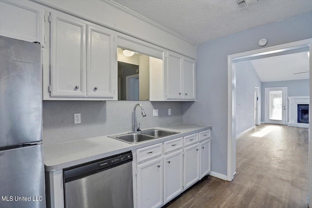 kitchen featuring a sink, dark wood finished floors, light countertops, white cabinets, and appliances with stainless steel finishes