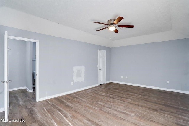 empty room featuring ceiling fan, baseboards, and wood finished floors