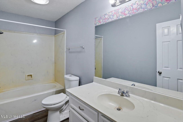 bathroom with toilet, wood finished floors, vanity, and washtub / shower combination