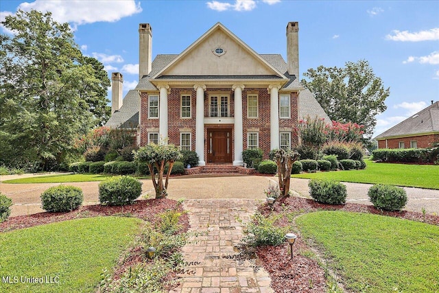 neoclassical home with a front lawn