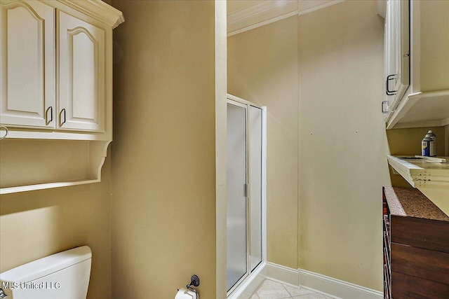 bathroom with toilet, tile patterned flooring, a shower with door, and ornamental molding