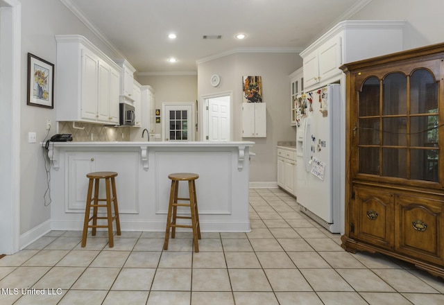 262 Geneva Blvd, Madison, MS 39110 - kitchen featuring white fridge with ice dispenser, a peninsula, a breakfast bar, white cabinetry, and recessed lighting