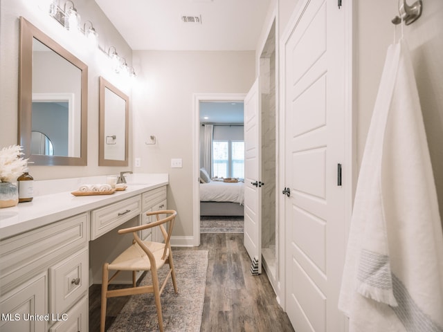10501 Glade Cv, Gulfport, MS 39503 - bathroom featuring double vanity, wood finished floors, and connected bathroom