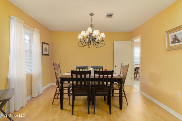 dining area with a chandelier and light hardwood / wood-style floors