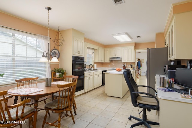 kitchen featuring decorative light fixtures, sink, a center island, light tile patterned floors, and black appliances