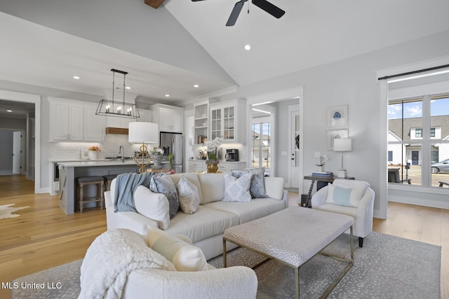 living area featuring high vaulted ceiling, recessed lighting, light wood finished floors, and a ceiling fan