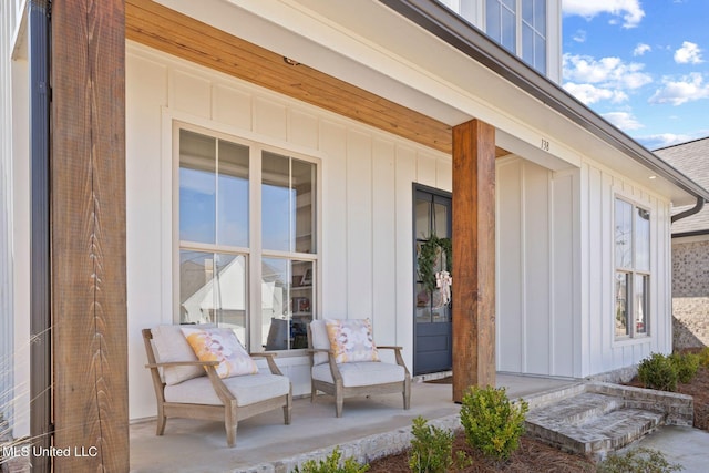 view of exterior entry with a porch and board and batten siding