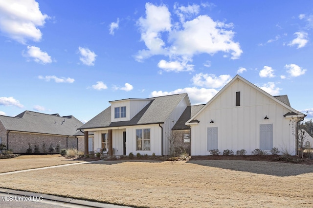 modern farmhouse style home with covered porch, board and batten siding, and roof with shingles