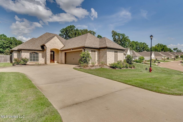 104 Cornerstone Dr, Madison, MS 39110 - french country style house featuring brick siding, concrete driveway, a front lawn, a garage, and a shingled roof
