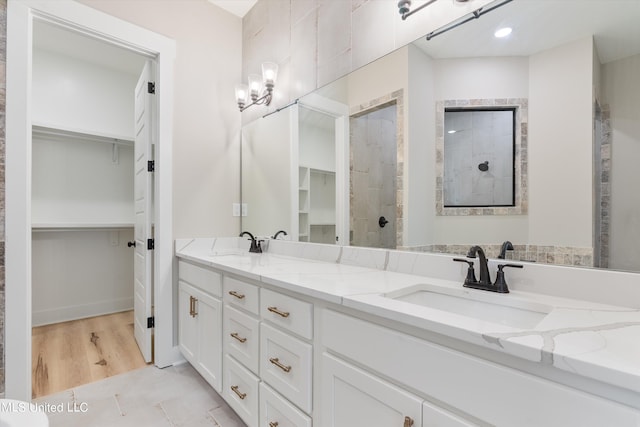 bathroom with hardwood / wood-style floors, vanity, and walk in shower