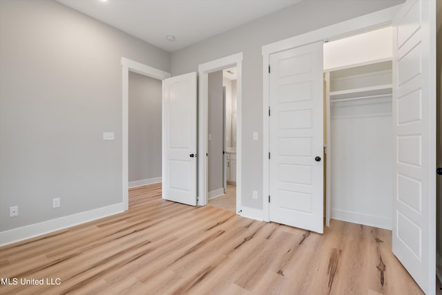 unfurnished bedroom with light hardwood / wood-style flooring and a closet