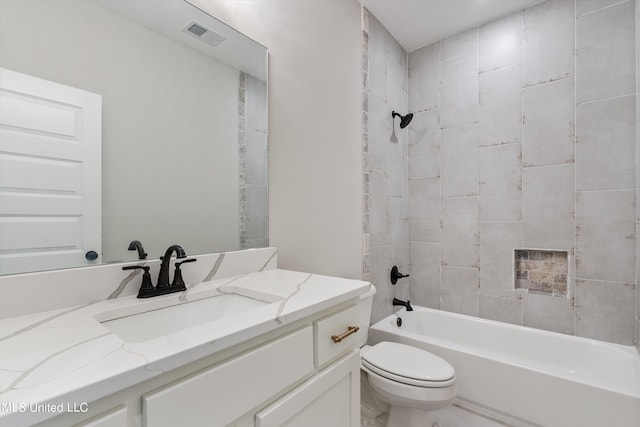 full bathroom featuring vanity, tiled shower / bath combo, and toilet