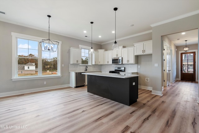 kitchen featuring hanging light fixtures, white cabinetry, a center island, and stainless steel appliances