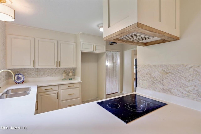 4638 Katherine Blvd, Jackson, MS 39211 - kitchen with a sink, black electric stovetop, decorative backsplash, light countertops, and white cabinets