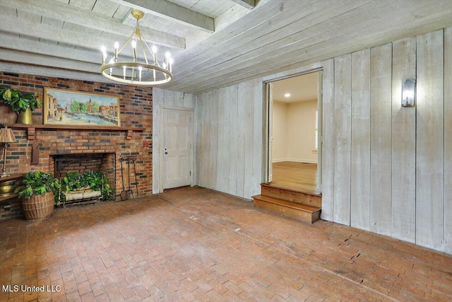 4638 Katherine Blvd, Jackson, MS 39211 - unfurnished living room featuring a chandelier, wooden walls, a fireplace, wood ceiling with exposed beams, and brick floors