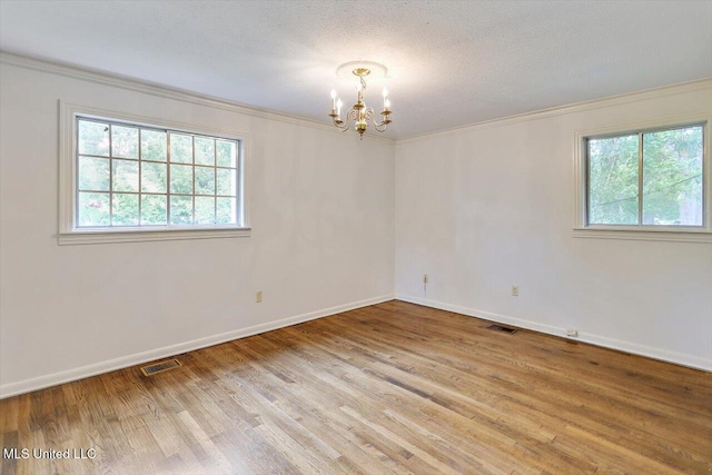 4638 Katherine Blvd, Jackson, MS 39211 - empty room featuring a chandelier, healthy amount of natural light, crown molding, baseboards, and a textured ceiling