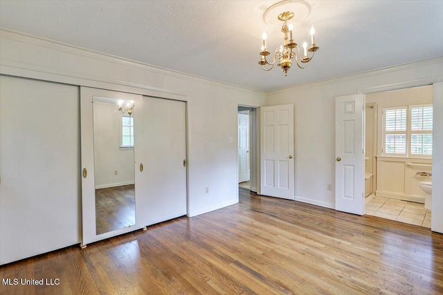 4638 Katherine Blvd, Jackson, MS 39211 - unfurnished bedroom featuring a chandelier, crown molding, a closet, wood finished floors, and ensuite bath