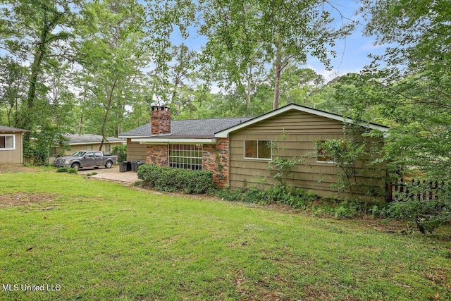 4638 Katherine Blvd, Jackson, MS 39211 - rear view of property featuring a chimney, a lawn, and brick siding