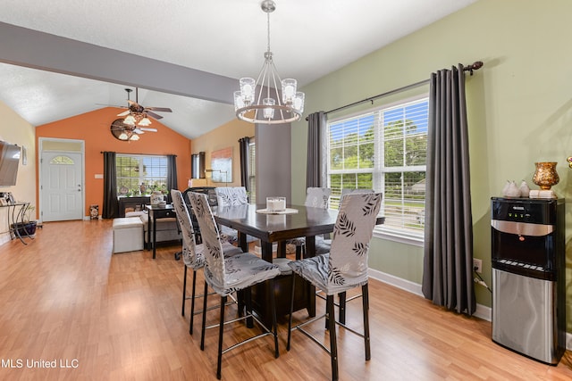 dining area featuring light hardwood / wood-style floors, lofted ceiling with beams, and ceiling fan with notable chandelier