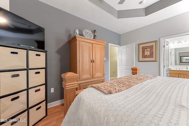 bedroom with connected bathroom, ceiling fan, a textured ceiling, and light hardwood / wood-style flooring