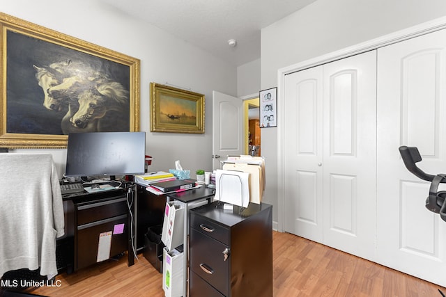 home office with light hardwood / wood-style flooring