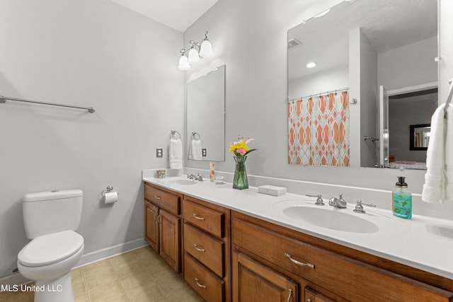 bathroom with toilet, vanity, and tile patterned flooring